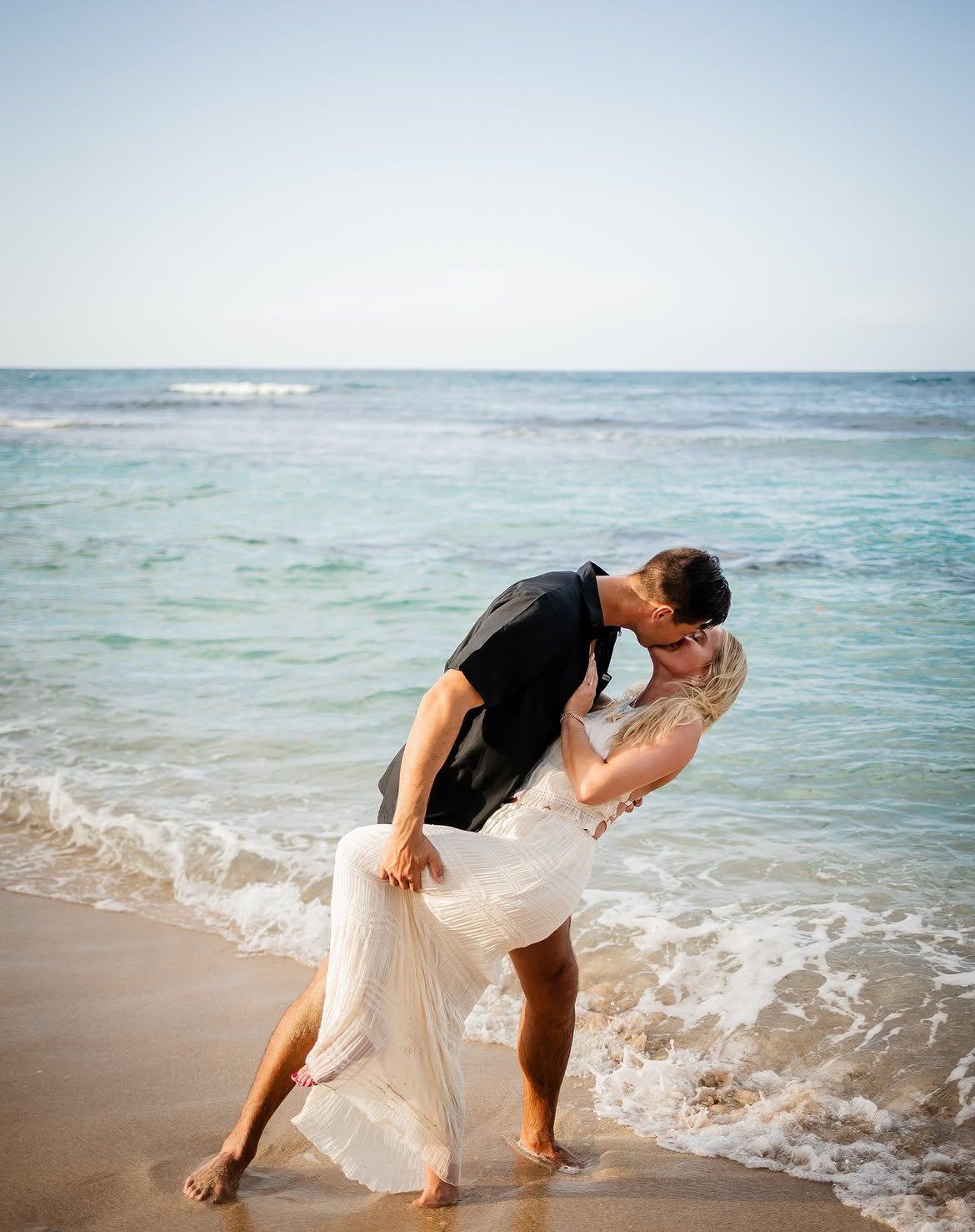 Couple sharing a dip kiss on a Jamaican beach, photographed by Snap Gen Studios