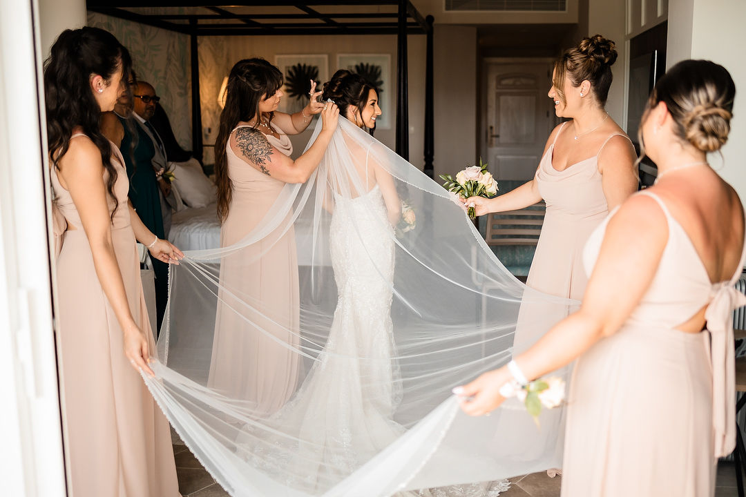 Bridesmaids adjusting bride's veil before wedding in Ocho Rios Jamaica